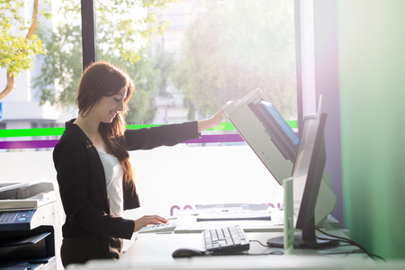 A young student at a copy center taking some copies for her final examsの写真素材