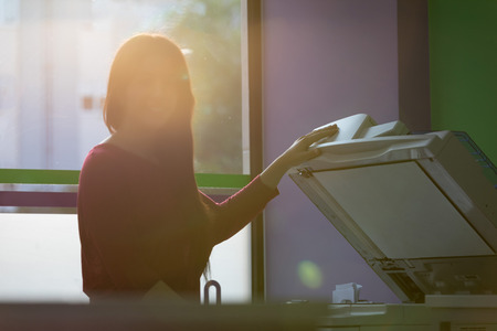 A young student at a copy center taking some copies for her final examsの写真素材