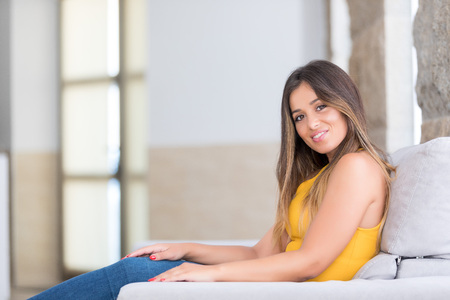 Beautiful young woman relaxing at homeの写真素材