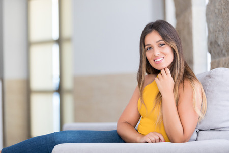 Beautiful young woman relaxing at homeの写真素材