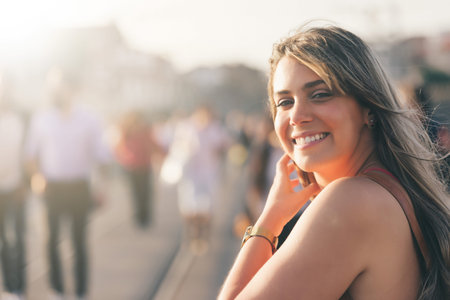 Young woman tourist enjoying beautiful landscape view on the old town with river and famous iron bridge during the sunset in Porto city, Portugalの写真素材