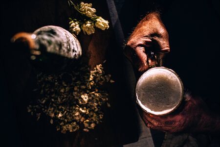 Male worker hand with beer and glass. Vintage feeling. Hipster like. With hop.の写真素材