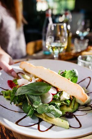hand serving a delicious sunny Italian lunch on a decorated tableの写真素材