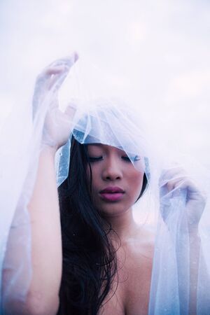 Asian model with bridal veil in the water enjoying a wellness spa.の写真素材