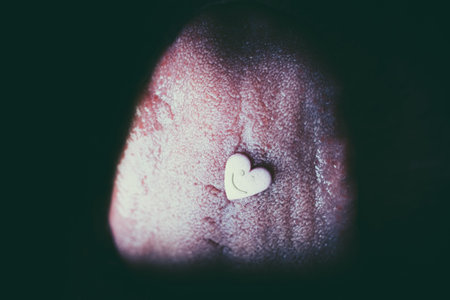Heart shaped pil on tongue in macro close-up.