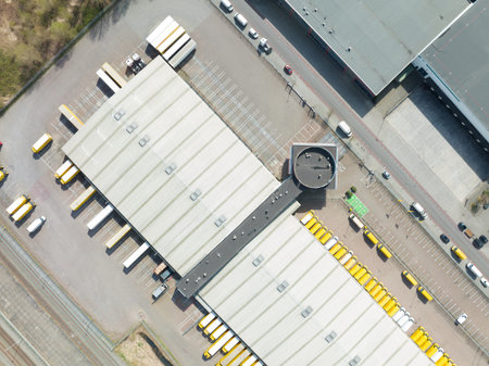 Utrecht, 3th of april 2022, The Netherlands. DHL delivery and distribution packaging warehouse with delivery trucks and vans company building. Aerial drone viewのeditorial素材