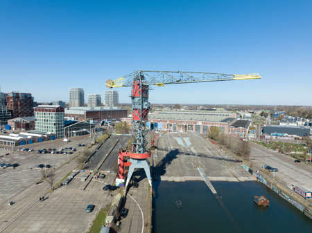 Amsterdam, 19th of March 2022, The Netherlands. NDSM wharf crane modern industrial shipyard and trendy residential area. Amsterdam Noord along the Ij river and waterway.のeditorial素材