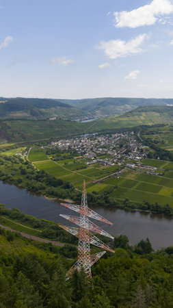 High voltage power infrastructure set against the scenic vineyards and river terrain near P nderich in the Moselle region.の写真素材