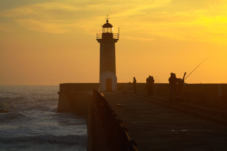 Lighthouse at sunset pr by the sea.