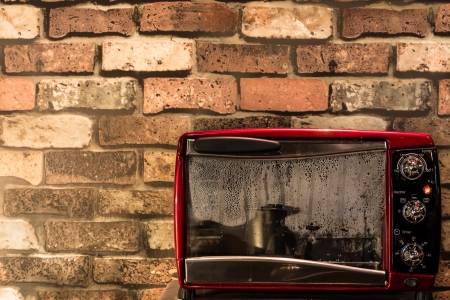 Vintage red oven with brick wallpaperの写真素材