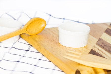 Wooden spoon and fork on trencher with little bowlの写真素材