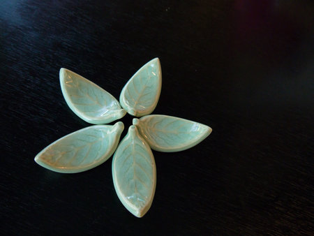 Ceramic leaves arrange on black tableの写真素材