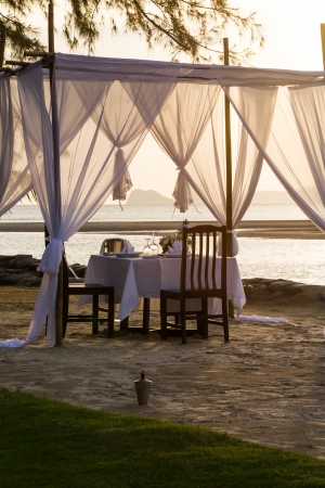 romantic dinner table setup on the beachの写真素材