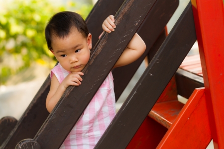 little girl waiting for mom at playgroundの写真素材