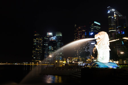 SINGAPORE - July 6, 2014 : Merlion and Marina Bay Sands by night. Merlion is a symbol of Singapore with the head of a lion and the body of fish.のeditorial素材