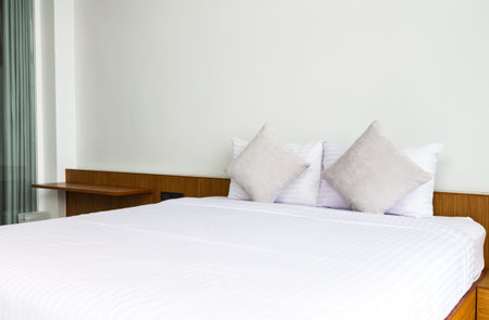 white clean bed with pillows in bedroomの写真素材