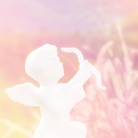 Little cupid sculpture in soft pastel lightの写真素材