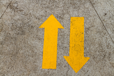 two way yellow arrows on roadの写真素材