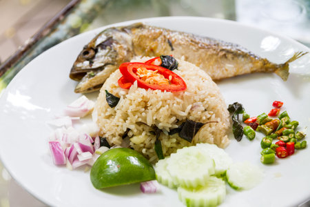 fried basil and rice with mackerel on white dishの写真素材