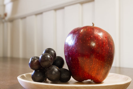 red apple and grape on wood plateの写真素材