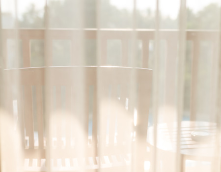 view through translucent white curtain at hotel room terraceの写真素材