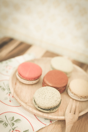colorful macarons on wooden dish in vintage toneの写真素材