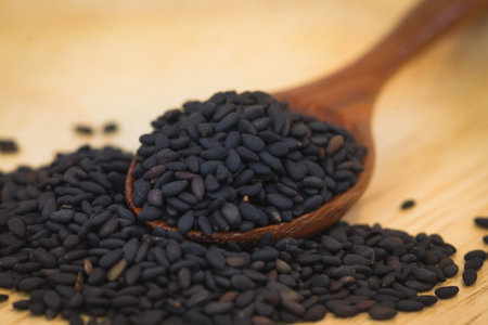black sesame in wood spoon on wooden backgroundの写真素材