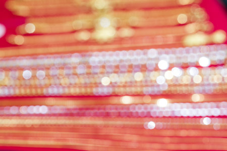 gold and silver bokeh from out of focus jewelry on red backgroundの写真素材