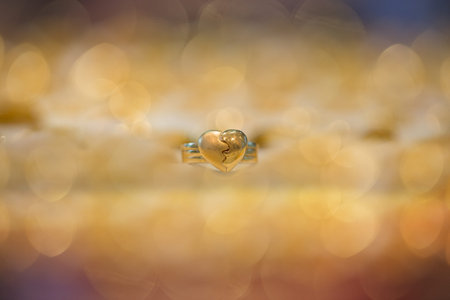 heart shape golden ring with bokeh backgroundの写真素材