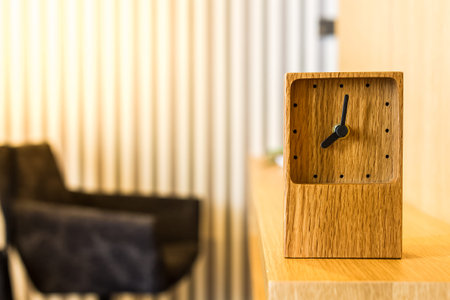 wooden clock decorated on worktableの写真素材