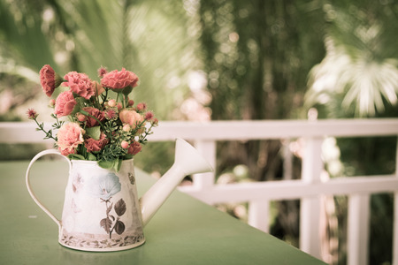 colorful fabric flowers in watering pot decorated on table, vintage toneの写真素材