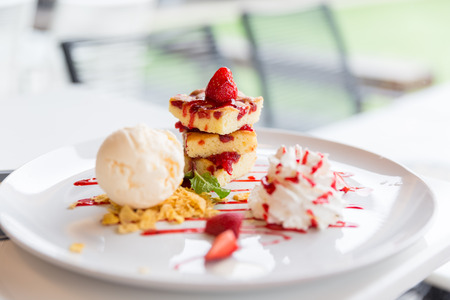 strawberry butter cake decorated with vanilla ice-cream and whipping creamの写真素材