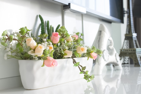 roses in white ceramic pot decorated in roomの写真素材
