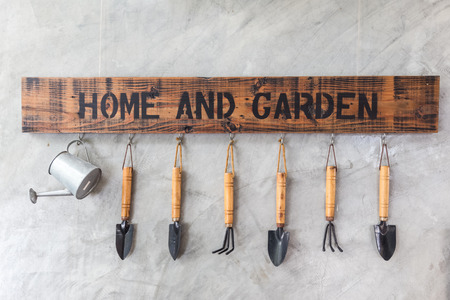 garden instruments hanging on cement wallの写真素材