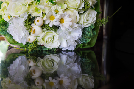 white roses flower bouquet with reflection on shiny black surface tableの写真素材