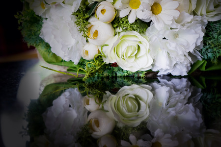 white roses flower bouquet with reflection on shiny black surface tableの写真素材
