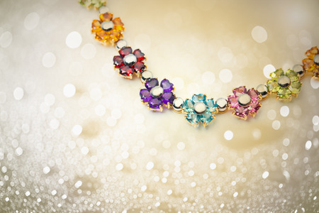 colorful flowers gems necklace on shiny bokeh backgroundの写真素材
