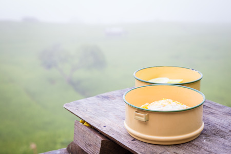 fried rice and fried egg in food carrier on wood balcony of farmhouse among rice field in the morningの写真素材