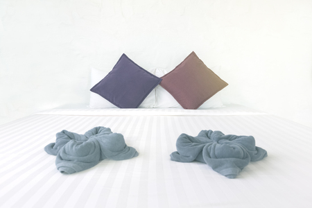 white clean bedsheet with colorful pillows in bedroomの写真素材