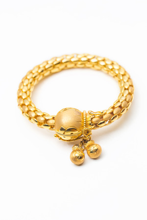 gold bangles with money bag hanging designed on white backgroundの写真素材