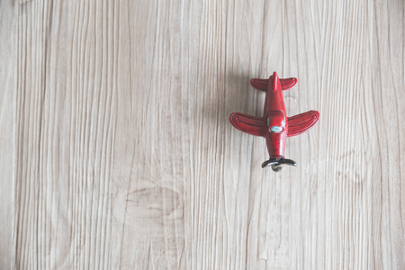 red toy plane on light brown wood backgroundの写真素材