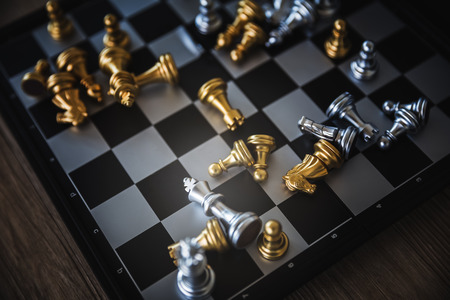 Gold and silver chessmen on checkerboard, concept for business competitionの写真素材