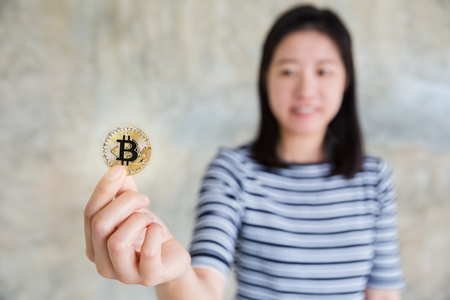 woman's hand holding golden bitcoinの写真素材