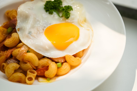 closeup fried egg topped on macaroniの写真素材