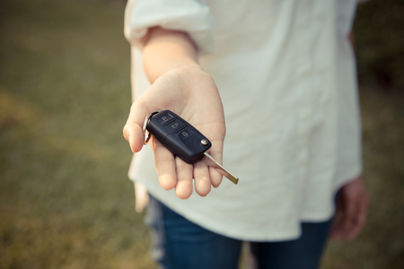 woman holding car remote key, automobile sales agent conceptの写真素材