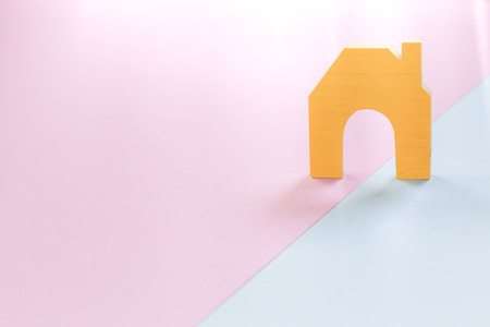 home shape wood on pink and blue paper background, concepts for real estate and businessの写真素材
