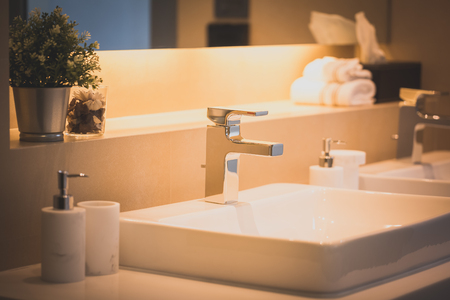 closeup faucet on bathroom sink with amenity decorationの写真素材