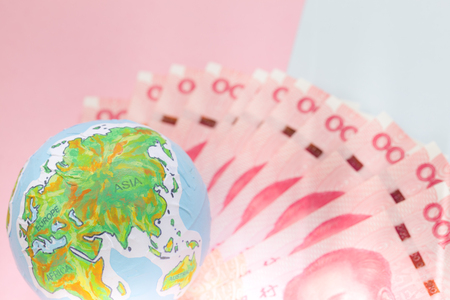 handmade globe on chinese banknotes, business and finance conceptsの写真素材