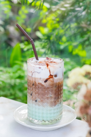 iced mocha mint served on table with green garden backgroundの写真素材