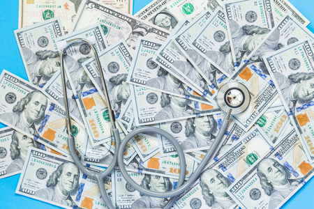 stethoscope on dollar notes background, health conceptの写真素材